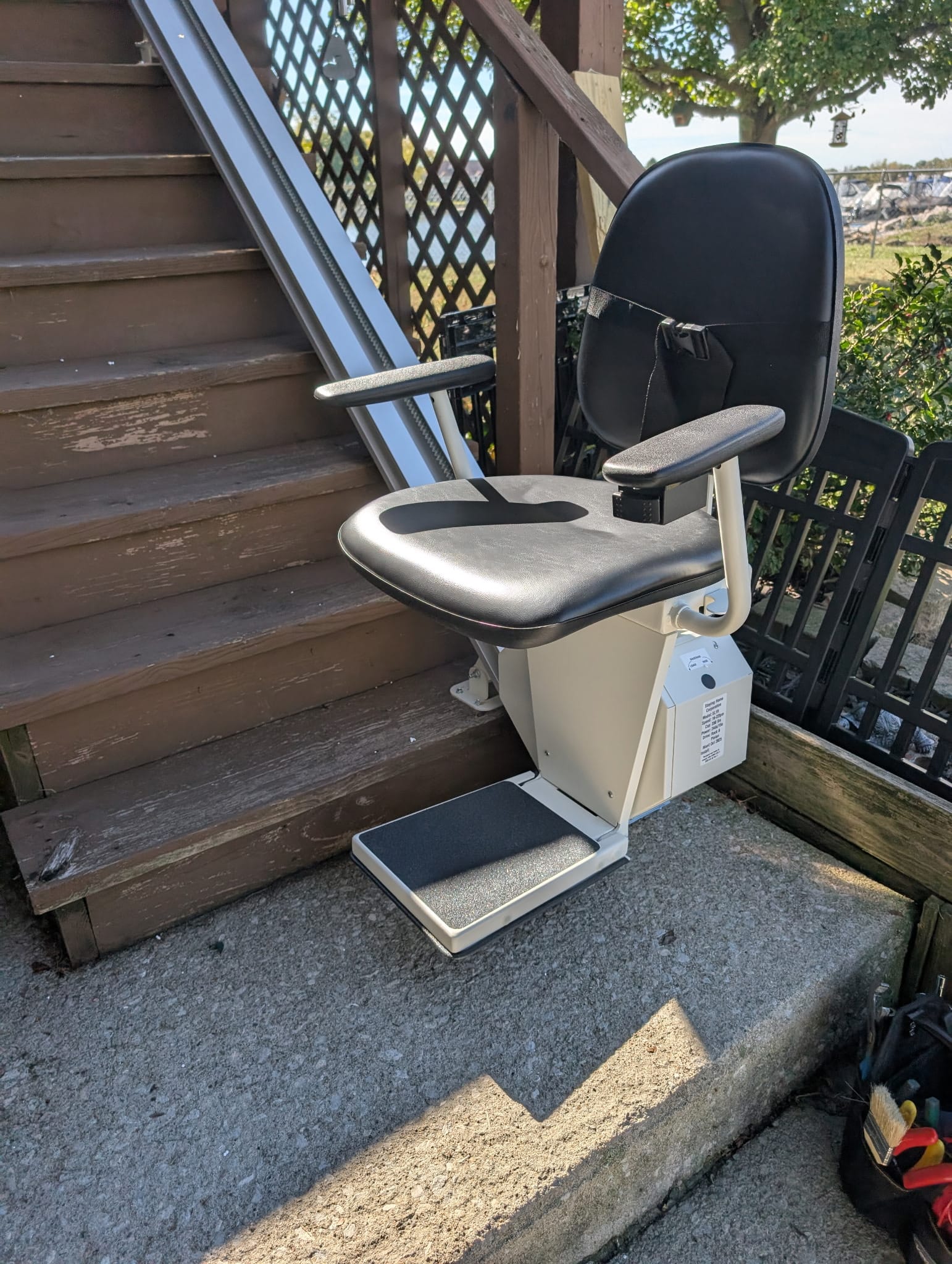Weatherproof outdoor stair lift mounted on residential exterior stairs for safe mobility