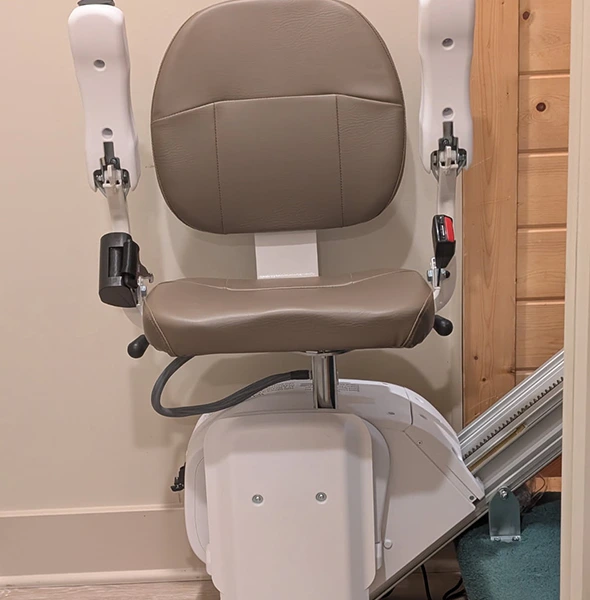 Comfortable stair lift chair with padded seat and armrests, ready for use.